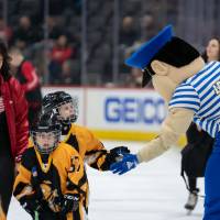 Louie the Laker high fives young hockey players